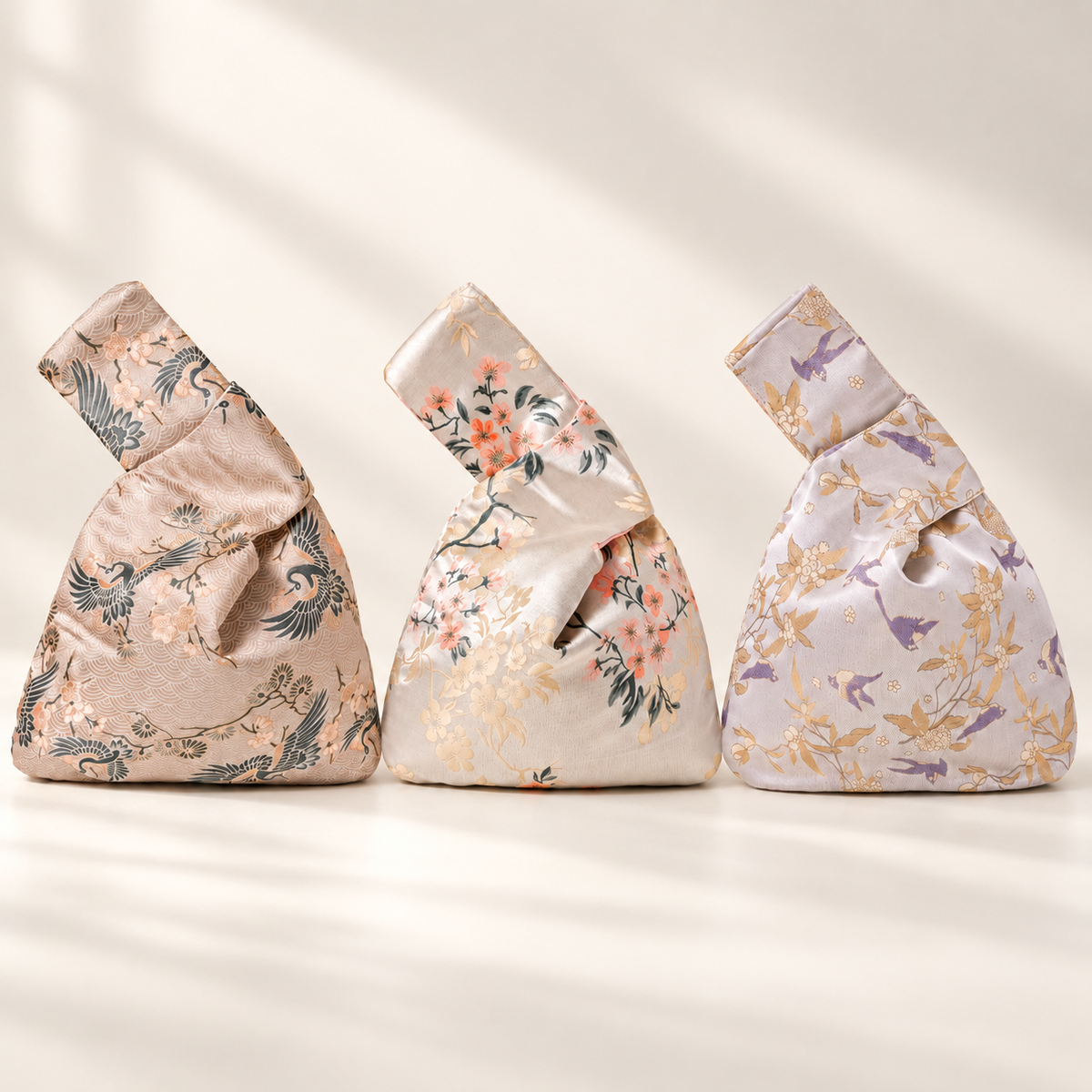 Champagne brocade Japanese knot bags in crane, blossom and swallow patterns; sold individually
