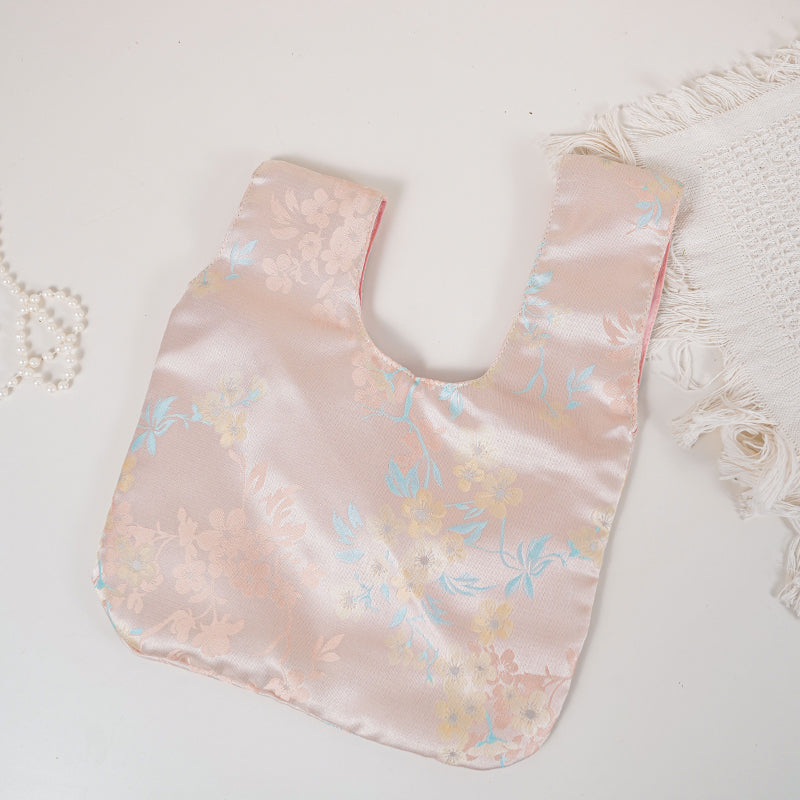 Flat lay of the blush pink blossom knot bag