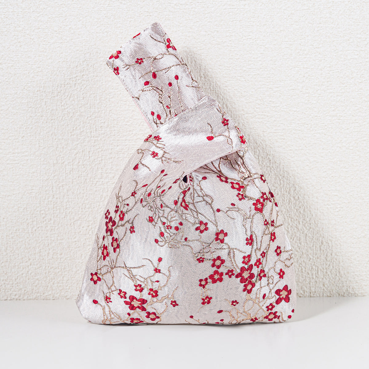 Knot bag with red blossoms on pale champagne-gold