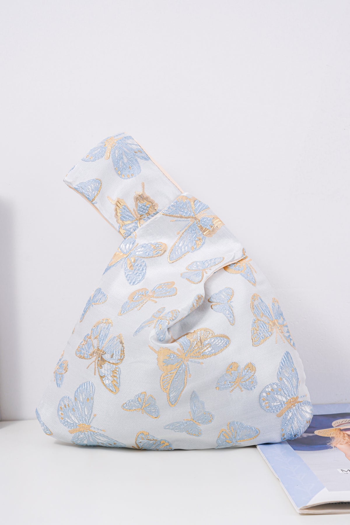 Blue butterfly satin knot bag with metallic jacquard motif