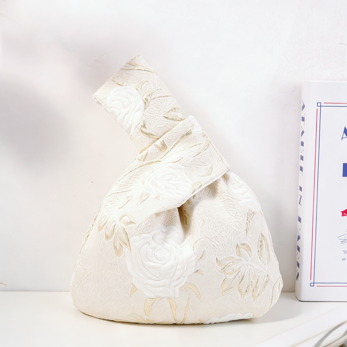 White rose satin knot bag with long-stemmed blooms
